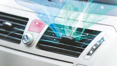 Close-up of a car's AC vent on a white dashboard, with blue and green swirls symbolizing cool air.