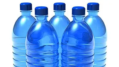Five blue plastic water bottles with dark blue caps grouped on a plain white background.