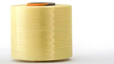 yellow kevlar para-aramid on spool on white background